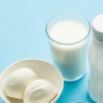 Protein products: cheese, cream, milk, eggs on the blue background.